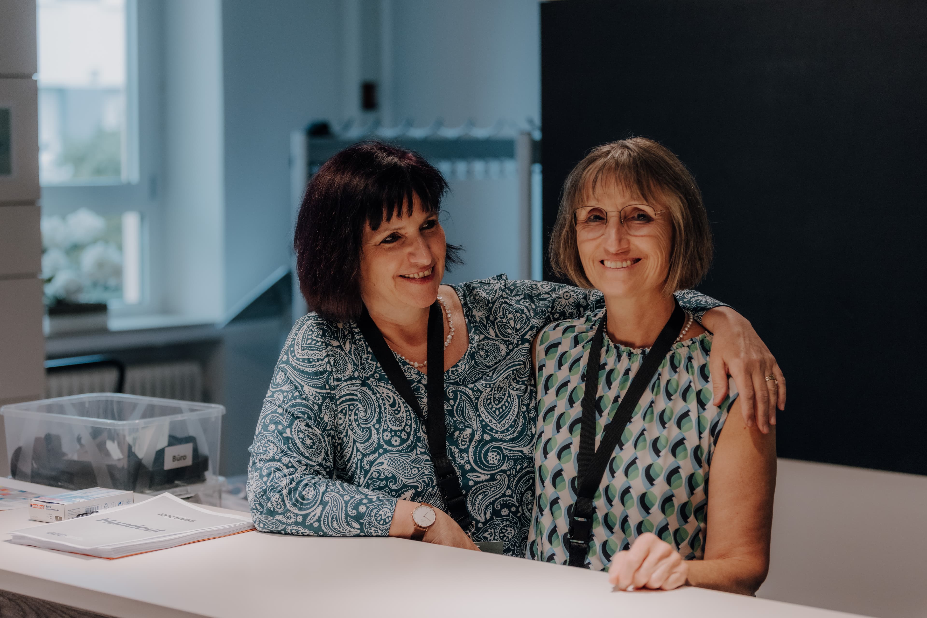Two women embrace and smile - living Christian community at GEC Heilbronn.